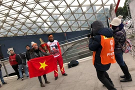 Những cổ động viên trẻ đầy nhiệt huyết trước ống kính phóng viên. (Ảnh: Vietnam+)