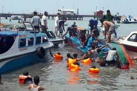 Lực lượng cứu hộ tìm kiếm nạn nhân sau vụ lật tàu ngày 25/7. (Nguồn: EPA/TTXVN)