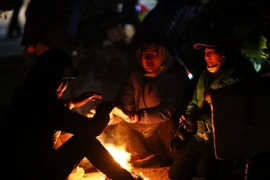 Người dân đốt lửa sưởi ấm trong buổi sáng giá rét. (Ảnh: Phan Tuấn Anh/TTXVN)