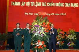 Thủ tướng Nguyễn Xuân Phúc tặng hoa chúc mừng Bộ Tư lệnh tác chiến Không gian mạng. (Ảnh: Thống Nhất/TTXVN)