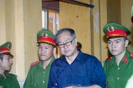 Dẫn giải bị cáo Phạm Công Danh ra xét xử tại phiên tòa 8/1. (Ảnh: Hoàng Hải/TTXVN)