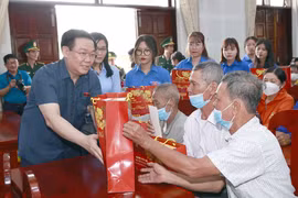 Chủ tịch Quốc hội Vương Đình Huệ tặng quà Tết gia đình chính sách, hộ nghèo, đồng bào dân tộc và công nhân lao động có hoàn cảnh khó khăn. (Ảnh: Doãn Tấn/TTXVN)