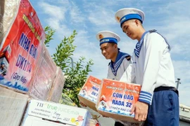 Các chiến sỹ chuyển quà Tết lên tàu. (Ảnh: Đoàn Mạnh Dương/TTXVN)