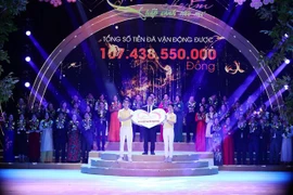 Đại diện Quỹ Bảo trợ trẻ em Việt Nam, Giám đốc Đinh Tiến Hải nhận ủng hộ của các nhà tài trợ. (Ảnh: Hoàng Hiếu/TTXVN)