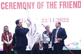 Phó Chủ tịch thường trực Quốc hội Trần Thanh Mẫn ký lên lá cờ của Hội đồng Hòa bình thế giới. (Ảnh: Minh Đức/TTXVN)