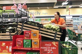 Nhân viên siêu thị Thành phố Hồ Chí Minh bổ sung thêm hàng hóa lên quầy, kệ vào sáng 23/1. (Ảnh: Mỹ Phương/TTXVN)