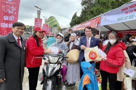 Phó chủ tịch UBND tỉnh Lâm Đồng Phạm S tặng quà cho người có hoàn cảnh khó khăn trong Hội chợ Tết nhân ái Xuân Quý Mão 2023. (Ảnh: Nguyễn Dũng/TTXVN)