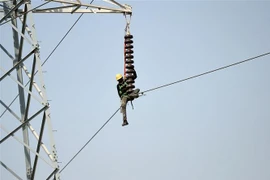 Kỹ thuật viên sửa chữa đường dây điện cao thế tại Karachi, Pakistan. (Ảnh: AFP/ TTXVN)