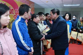 Thủ tướng Phạm Minh Chính tặng quà cho công nhân, người lao động, người có hoàn cảnh khó khăn tỉnh Nam Định. (Ảnh: Dương Giang/TTXVN)