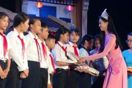 Hoa hậu Việt Nam 2018 Trần Tiểu Vy tặng quà cho trẻ em có hoàn cảnh đặc biệt khó khăn. (Ảnh: Đoàn Hữu Trung/TTXVN)