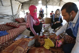 Bác sỹ thuộc UNRWA kiểm tra sức khỏe cho một em nhỏ Palestine tại trại tị nạn ở ngoại ô thành phố Hebron, Bờ Tây. (Nguồn: AFP/TTXVN)