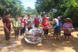 Cán bộ Hội Chữ thập Đỏ tỉnh Thanh Hóa trao quà đến người dân vùng lũ huyện Yên Định. (Ảnh: Khiếu Tư/TTXVN)