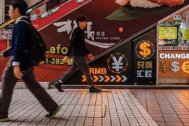 Người đi bộ đi qua một cửa hàng trao đổi tiền tệ ở Hong Kong. (Nguồn: Bloomberg News)