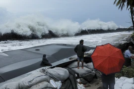Người dân đặt bao cát ngăn các con sóng lớn do ảnh hưởng của bão Maha tại Chellanam, Ấn Độ. (Nguồn: AFP/TTXVN)