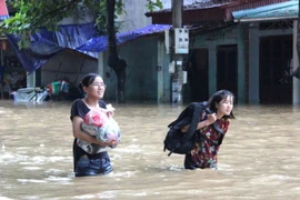 Thí sinh Hà Giang vượt lũ đến trường thi. (Ảnh: Minh Tâm/TTXVN)