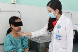 Bác sỹ Võ Thị Đoan Phượng, Trưởng Khoa Lâm sàng 1, Bệnh viện Da Liễu Thành phố Hồ Chí Minh khám cho bệnh nhân. (Nguồn: TTXVN)