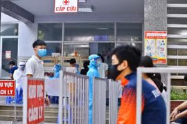 Người dân đến lấy mẫu xét nghiệm được bố trí ngồi chờ theo khu vực quy định. (Ảnh: Minh Quyết/TTXVN)