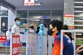 Người dân đến lấy mẫu xét nghiệm được bố trí ngồi chờ theo khu vực quy định. (Ảnh: Minh Quyết/TTXVN)
