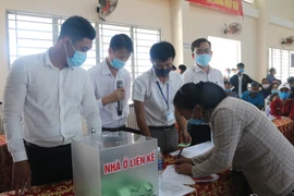 Các hộ dân thuộc diện phải giải tỏa, di dời ký nhận đất tái định cư đã bốc thăm. (Ảnh: Lê Xuân/TTXVN)