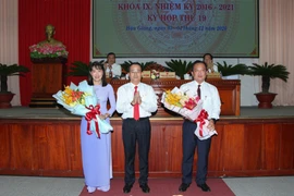 Ông Trần Văn Huyến, Phó Bí thư Thường trực Tỉnh ủy, Chủ tịch Hội đồng Nhân dân tỉnh Hậu Giang tặng hoa chúc mừng bà Hồ Thu Ánh và ông Nguyễn Văn Hòa. (Ảnh: Hồng Thái/TTXVN)