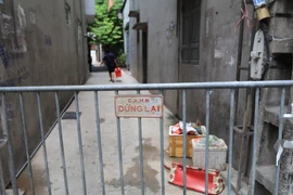 Lực lượng chức năng phong tỏa khu vực ngõ 230/26 Mễ Trì Thượng, nơi có trường hợp nghi nhiễm COVID-19 đang sinh sống để phun thuốc khử khuẩn. (Ảnh: Lê Phú/TTXVN)