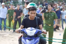 Nghi phạm Giáp tiến hành thực nghiệm hiện trường vụ án. (Ảnh: PV/Vietnam+) 
