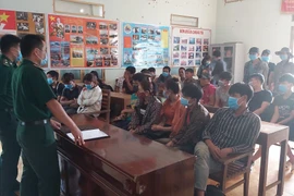 Lực lượng biên phòng của Đồn biên phòng Xín Cái lấy lời khai của nhóm đối tượng xuất, nhập cảnh trái phép. (Nguồn: TTXVN) 