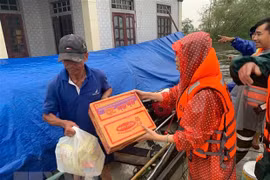 Hỗ trợ lương thực cho người dân vùng lũ. (Ảnh: TTXVN phát)
