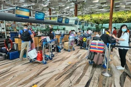 Các công dân làm thủ tục chờ lên máy bay về nước. (Nguồn: TTXVN)