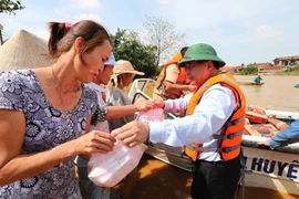 Bộ trưởng Bộ Kế hoạch Đầu tư Nguyễn Chí Dũng phát quà cứu trợ cho người dân tại huyện Lệ Thủy (Quảng Bình). (Ảnh: Thành Đạt/TTXVN) 