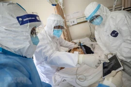 Nhân viên y tế điều trị cho bệnh nhân nhiễm COVID-19 tại bệnh viện ở Vũ Hán, Trung Quốc, ngày 16/2. (Ảnh: AFP/TTXVN)