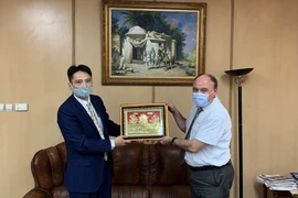 Đại sứ Nguyễn Thành Vinh tặng quà lưu niệm cho Tổng Giám đốc Hãng Thông tấn APS Fakhreddine Beldi (phải). (Ảnh: Tấn Đạt/ TTXVN)