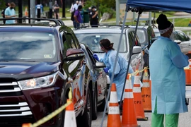 Nhân viên y tế lấy mẫu dịch xét nghiệm COVID-19 cho người dân tại Arlington, Virginia, Mỹ, ngày 26/5/2020. (Nguồn: AFP/TTXVN)