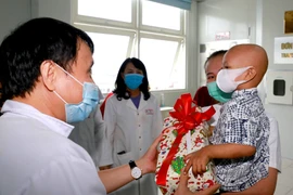 Lãnh đạo bệnh viện tặng quà cho bệnh nhi ngày ra viện. (Ảnh: TTXVN phát)