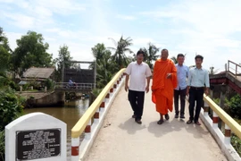 Đại đức Danh Dung đã vận động các tổ chức, cá nhân và người dân đóng góp xây dựng cầu dân sinh phục vụ bà con đi lại thuận tiện, an toàn. (Ảnh: Lê Sen/ TTXVN)