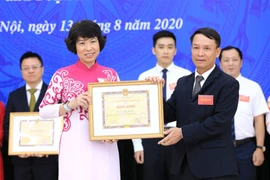 Tổng Giám đốc TTXVN Nguyễn Đức Lợi trao Bằng khen tặng Phó Tổng giám đốc TTXVN Vũ Việt Trang. (Ảnh: Thành Đạt/TTXVN)