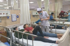 Các công nhân mắc các triệu chứng nghi ngộ độc thực phẩm đang được điều trị tích cực tại Bệnh viện đa khoa Đồng Nai. (Ảnh: Lê Xuân/TTXVN)