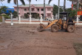 Xe cơ giới tham gia thu don bùn đất tại các trục đường giai thông tại thị xã Quảng Trị. (Ảnh: Hồ Cầu/TTXVN)