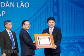Phó Thủ tướng chính phủ Lào Somdee Duangdee (giữa) trao tặng Huân chương Lao động hạng Nhất cho LaoVietBank. (Ảnh: Xuân Tú/TTXVN)