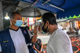 Kiểm tra thân nhiệt phòng lây nhiễm COVID-19 tại Kuala Lumpur, Malaysia ngày 23/11/2020. (Ảnh: THX/TTXVN)