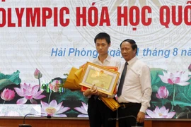 Bí thư Thành ủy Hải Phòng Lê Văn Thành khen thưởng học sinh Lý Hải Đăng. (Ảnh: Minh Thu/TTXVN)