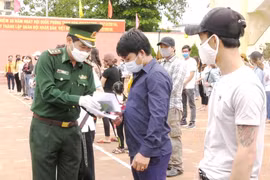 Cán bộ biên phòng trao Giấy chứng nhận hoàn thành cách ly phòng chống dịch bệnh COVID-19 cho các công dân. (Ảnh: Võ Dung/TTXVN)