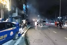 Chiếc xe taxi bị văng xa, hỏng nặng sau cú đâm liên hoàn. (Nguồn: TTXVN)