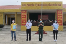 Đại diện trường Quân sự, Quân đoàn I, tỉnh Ninh Bình trao giấy chứng nhận hoàn thành thời gian cách ly cho công dân. (Ảnh: Hải Yến/TTXVN)