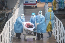 Nhân viên y tế chuyển bệnh nhân nhiễm virus corona chủng mới tới điều trị tại bệnh viện dã chiến Hỏa Thần Sơn ở Vũ Hán. (Ảnh: THX/TTXVN)