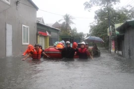 Lực lượng chức năng sơ tán 200 hộ dân phường Bến Thủy, thành phố Vinh) đến nơi an toàn. (Ảnh: Bích Huệ/TTXVN) 