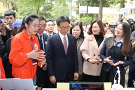 Phó Thủ tướng Chính phủ Vũ Đức Đam cùng đại biểu tham quan các không gian trưng bày ý tưởng khởi nghiệp của học sinh, sinh viên. (Ảnh: Thanh Tùng/TTXVN)