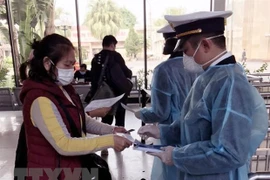Tại cửa khẩu Móng Cái, cán bộ Kiểm dịch Y tế Quốc tế Quảng Ninh tăng cường giám sát khách nhập cảnh. (Ảnh: TTXVN)