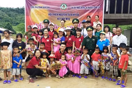 Các em nhỏ và nhiều gia đình có hoàn cảnh khó khăn, chính sách ở Bản Sắt, xã Trường Sơn, huyện Quảng Ninh, Quảng Bình nhận quà, bánh Trung Thu từ các tấm lòng thiện nguyện. (Ảnh: Võ Dung/TTXVN) 