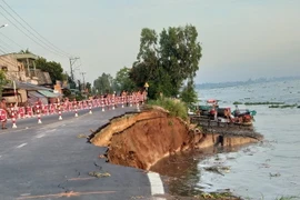 Sạt lở ăn sâu vào tuyến Quốc lộ 91 cũ. (Ảnh: Công Mạo/TTXVN)